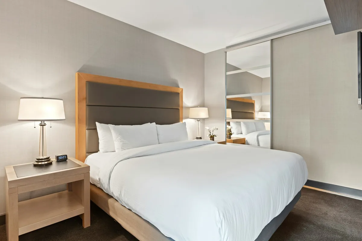 Chambre d'hôtel sobre avec lit double et lampes de chevet