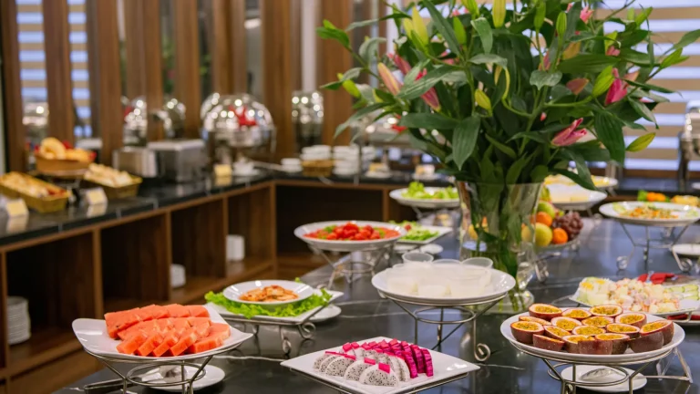 Buffet de petit-déjeuner d'hôtel avec fleurs, fruits et pâtisseries