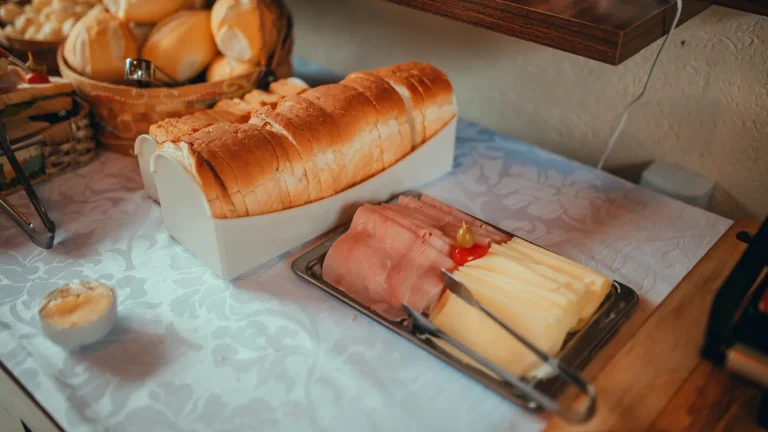 Petit déjeuner d'hôtel : corbeille de pains et plateau de charcuteries et fromages