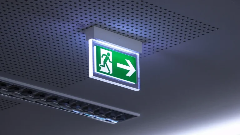 Panneau lumineux de sortie de secours suspendu au plafond d'un couloir