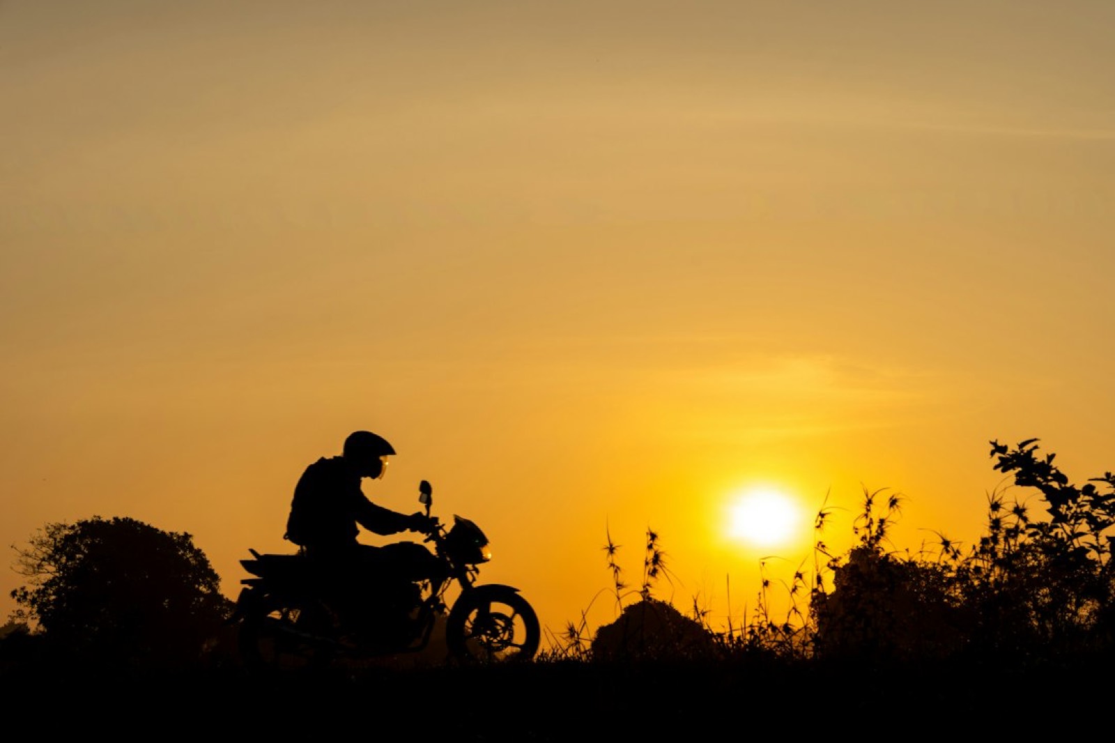 Pilote casqué sur véhicule sportif au coucher du soleil